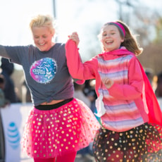 Two Girls on the Run participants smile while showing off 5K medals